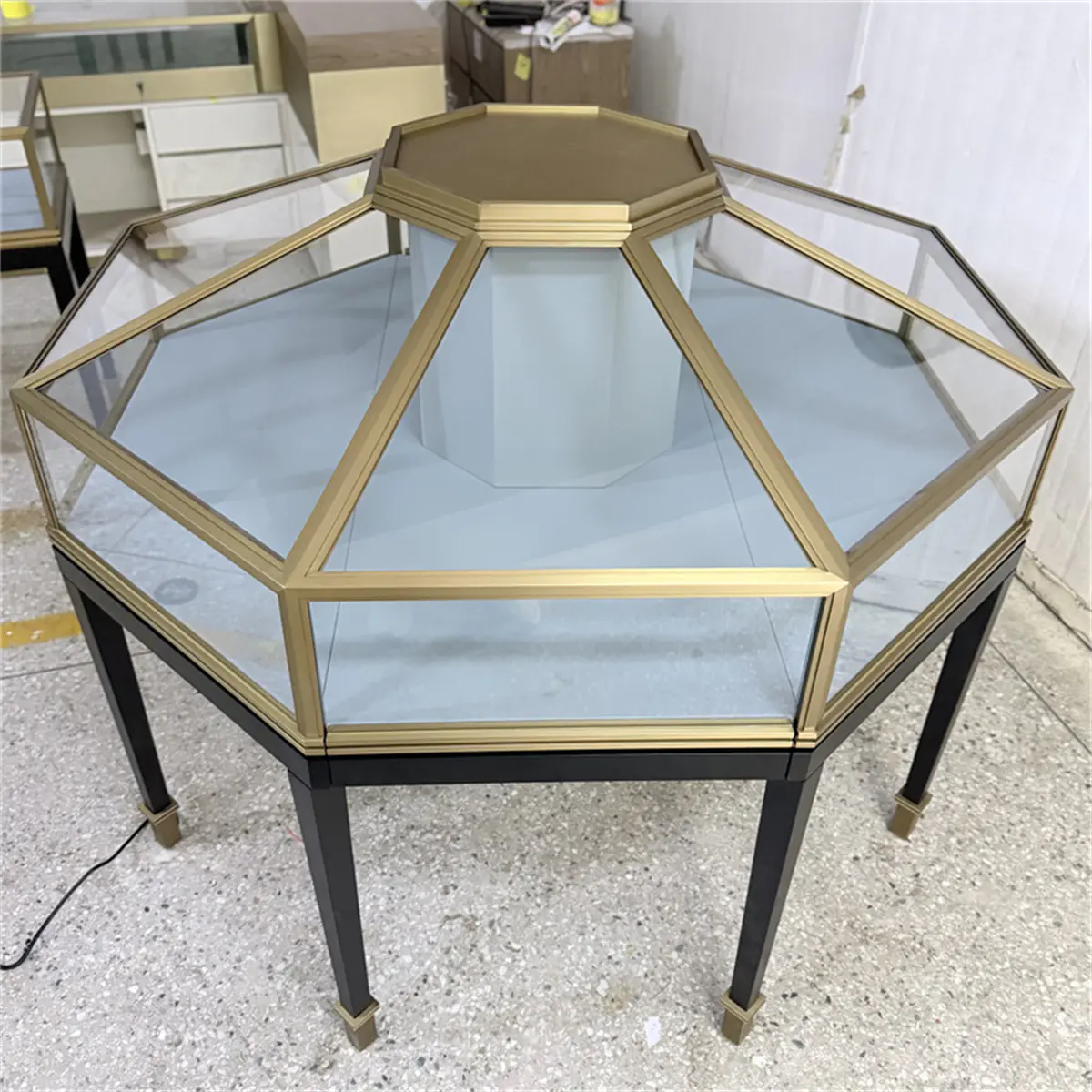 Unlit Custom Octagonal Jewelry Showcases showing precise glass joints, a blue interior, and gold metal finish.